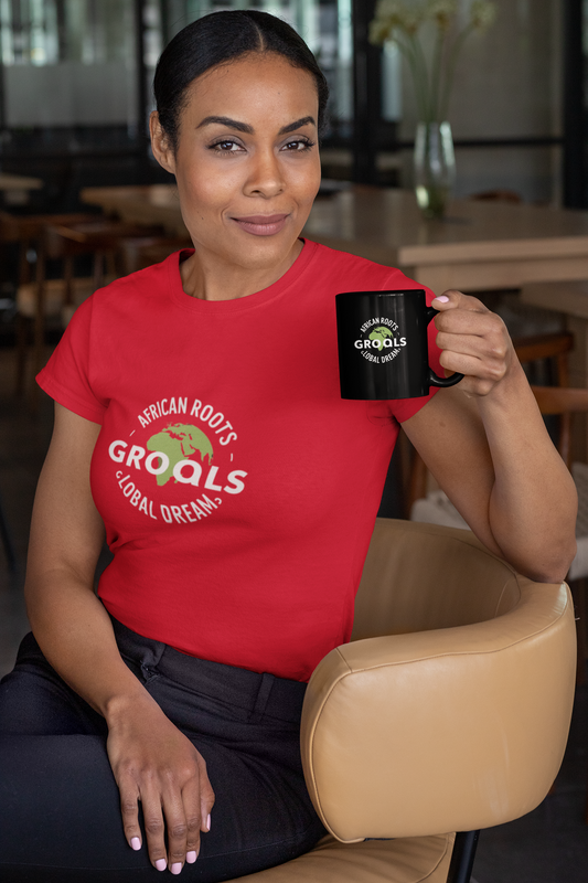 Woman wearing a red African Roots Global Dreams T-shirt while holding a matching black mug.